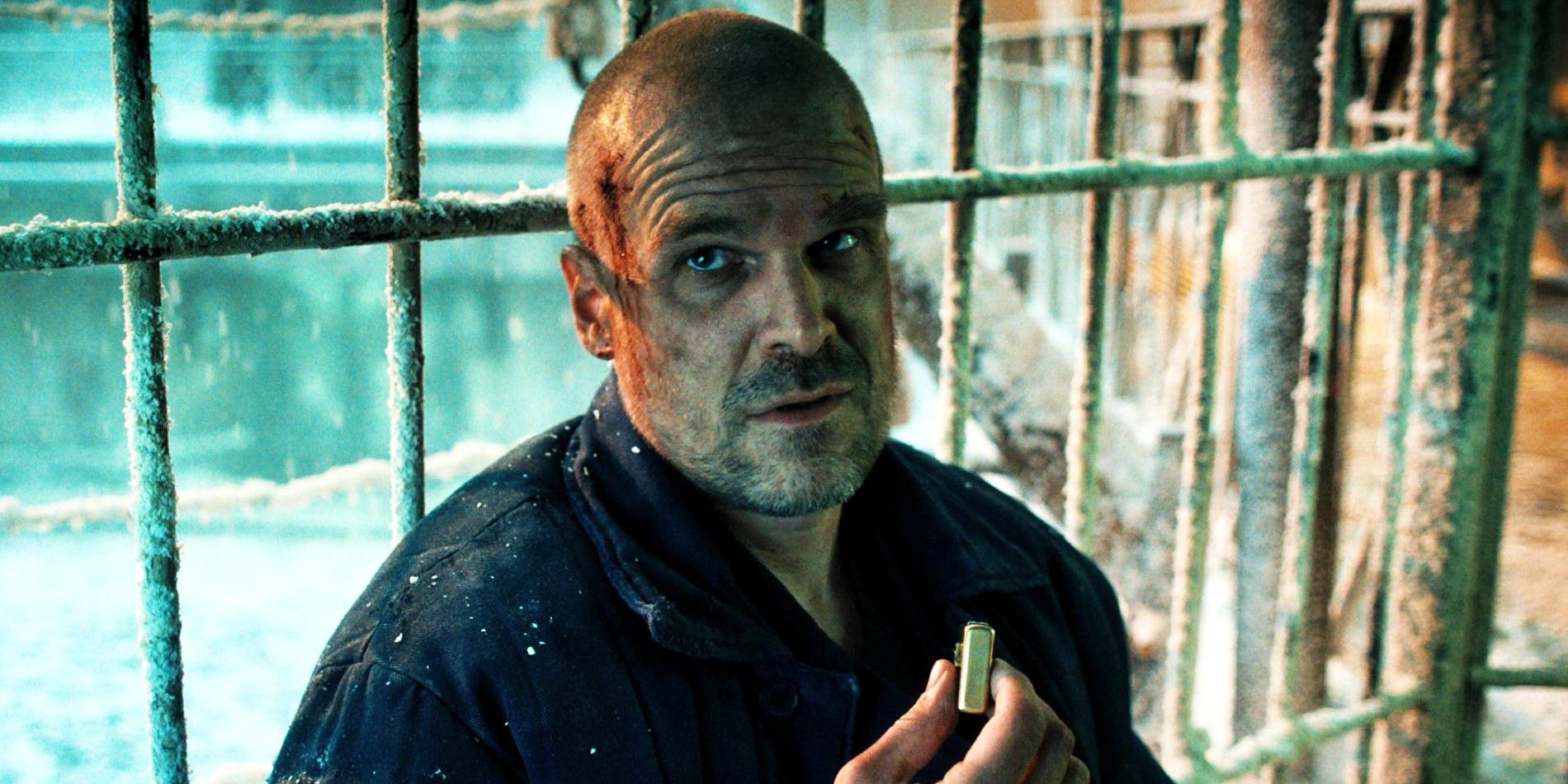 David Harbour as Hopper in Stranger Things season 4 leaning against prison cell bars