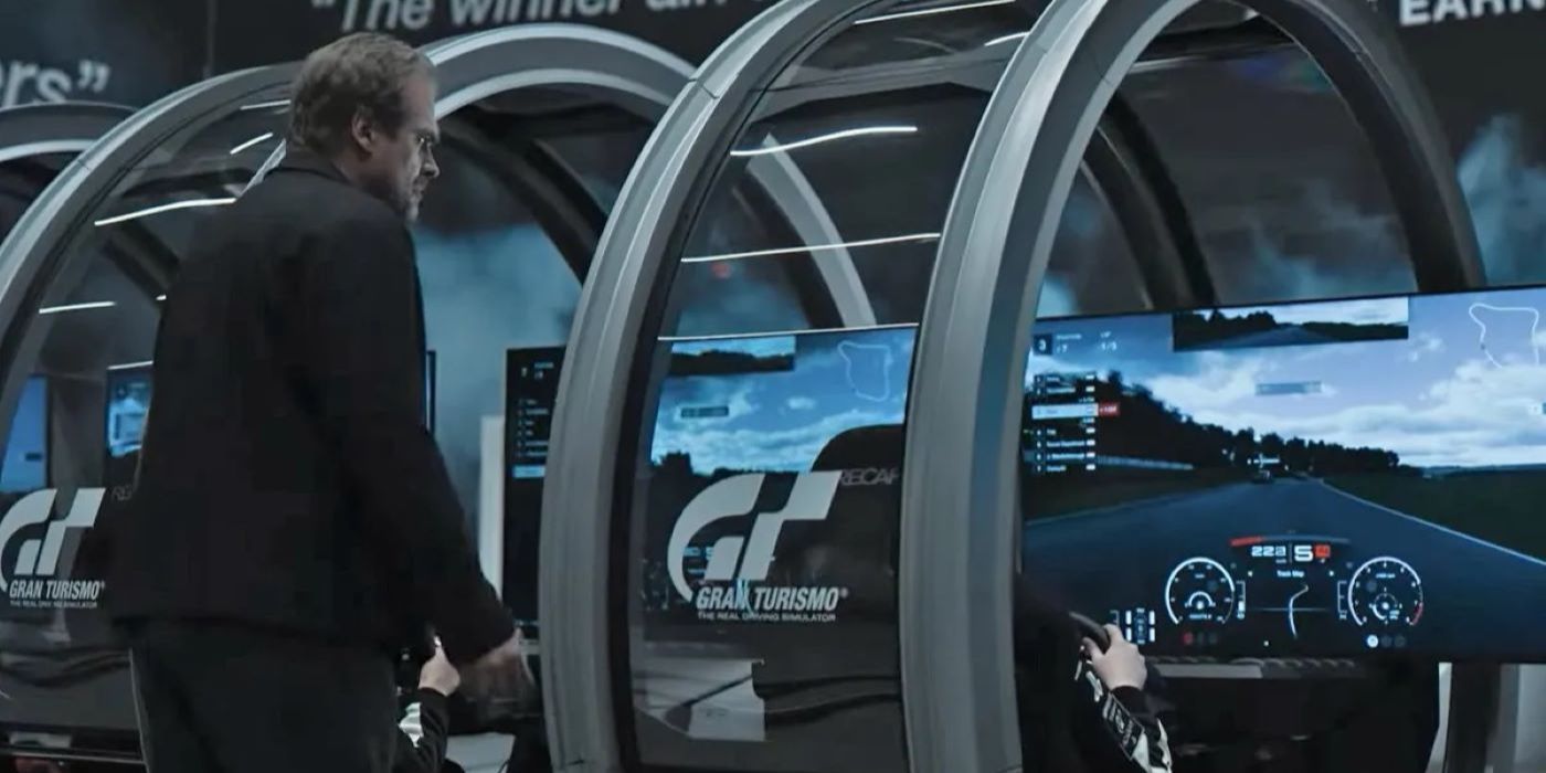 David Harbour looking over a racing console in Gran Turismo the movie. 