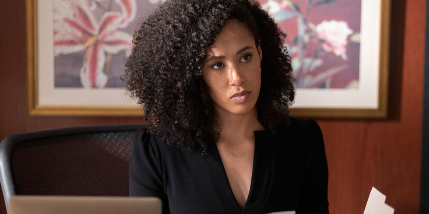 Evie (Margot Bingham) sentada em uma mesa em Nova Amsterdã