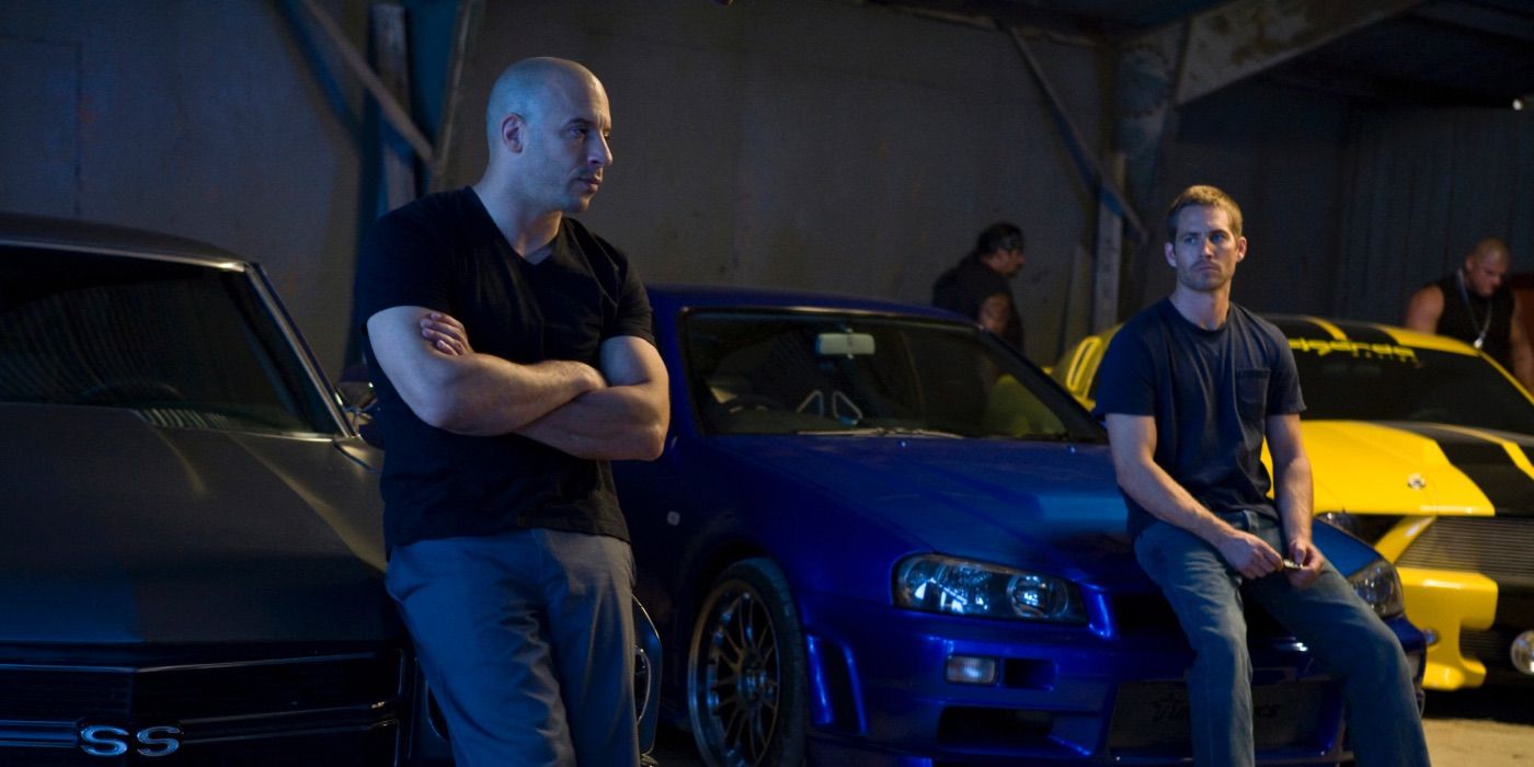 Dom and Brian lean against their cars in Fast & Furious 