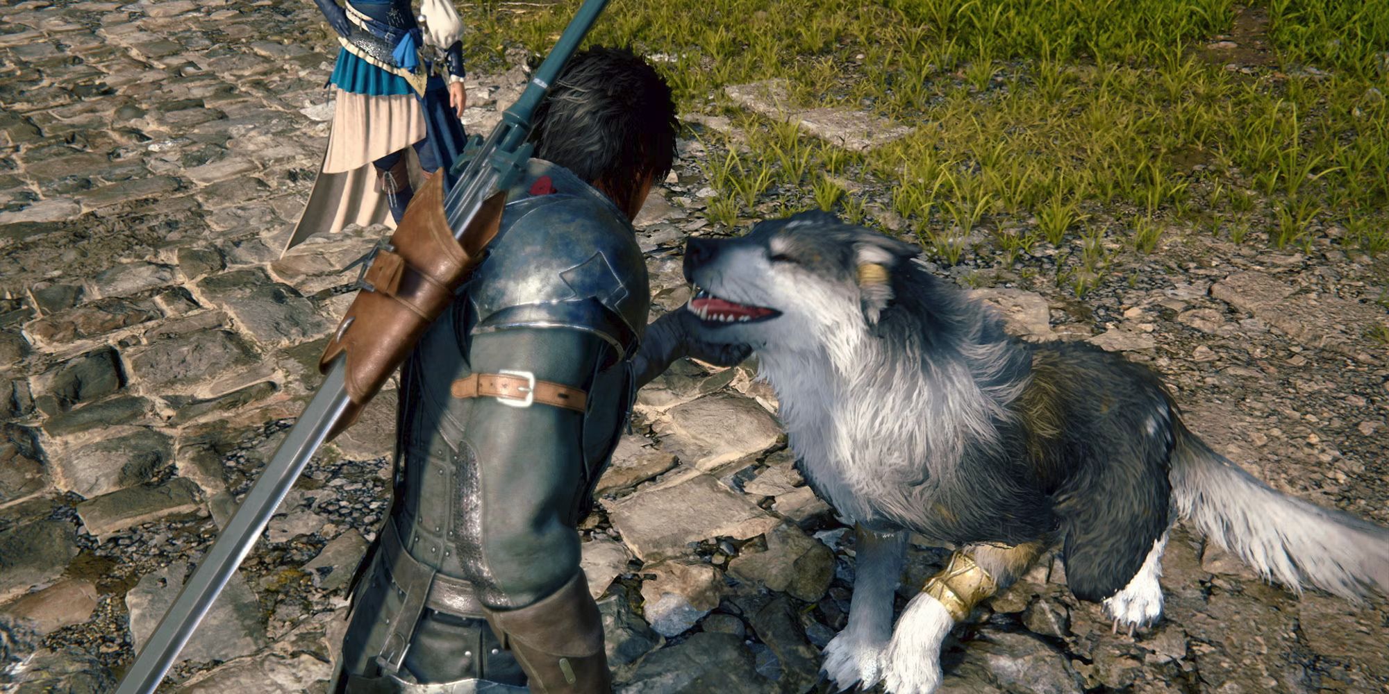 Clive, wearing black leather armor and carrying a sword, gives his long-haired, black and white dog Torgal a chin scratch in Final Fantasy 16.