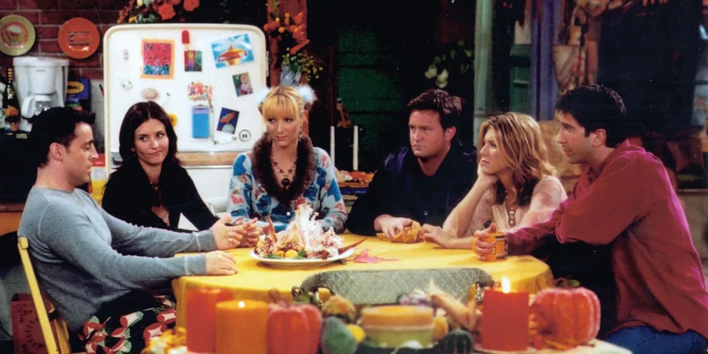 The cast of Friends sitting around a table in Monica and Rachel's apartment.