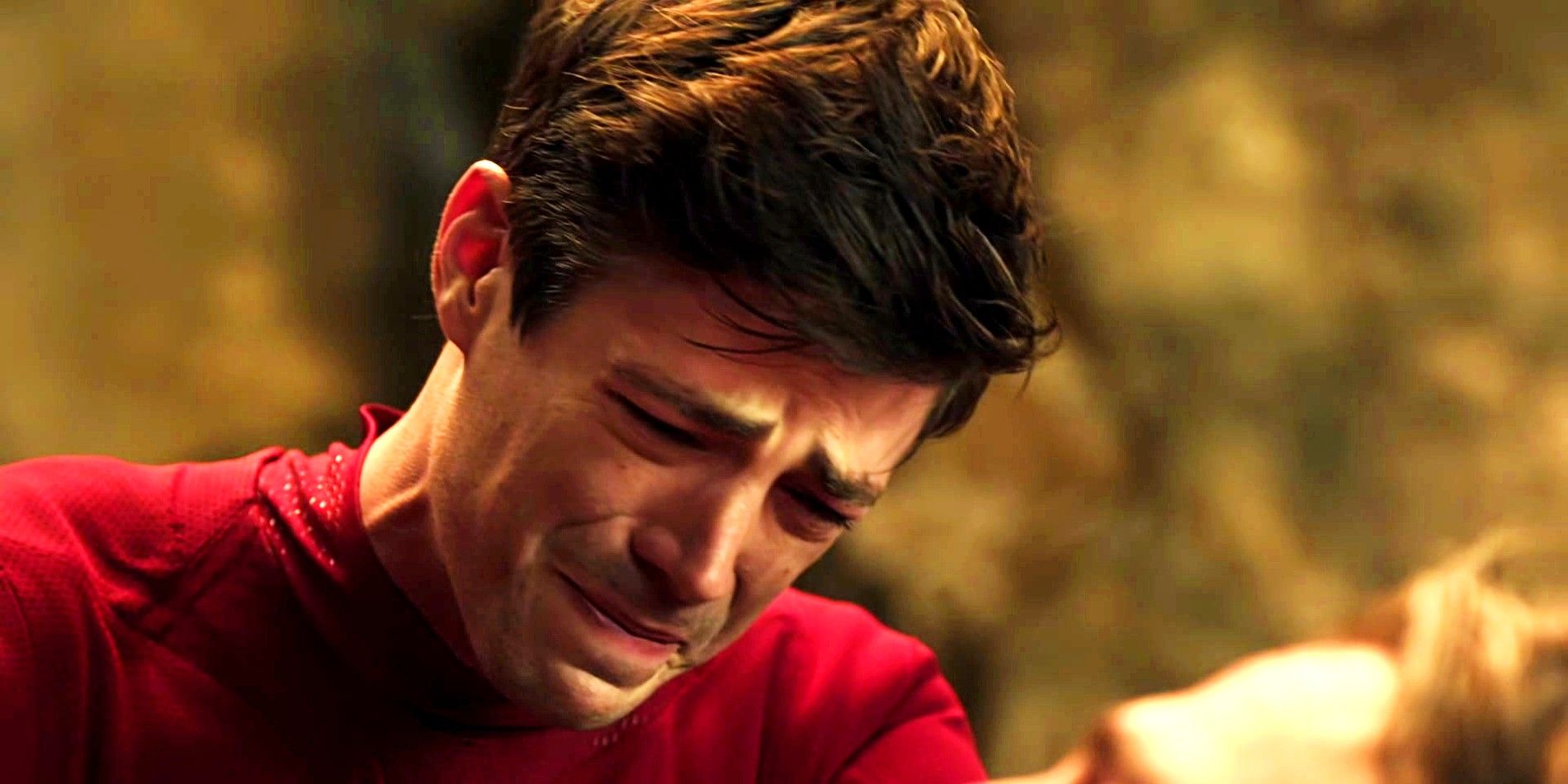 Grant Gustin dans le rôle de Flash pleurant la mort d'Oliver Queen dans Arrow Crisis on Infinity Earths