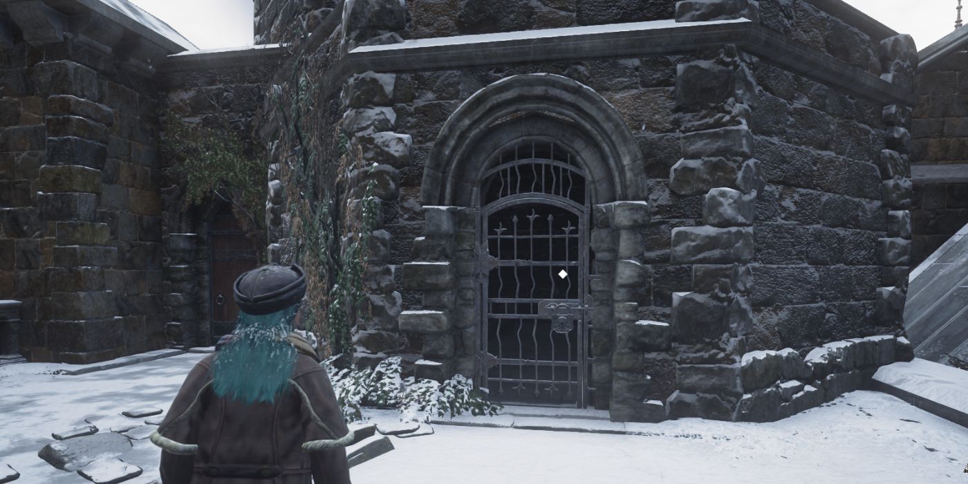 A Hogwarts Legacy player standing outside a locked metal gate in snowy weather.