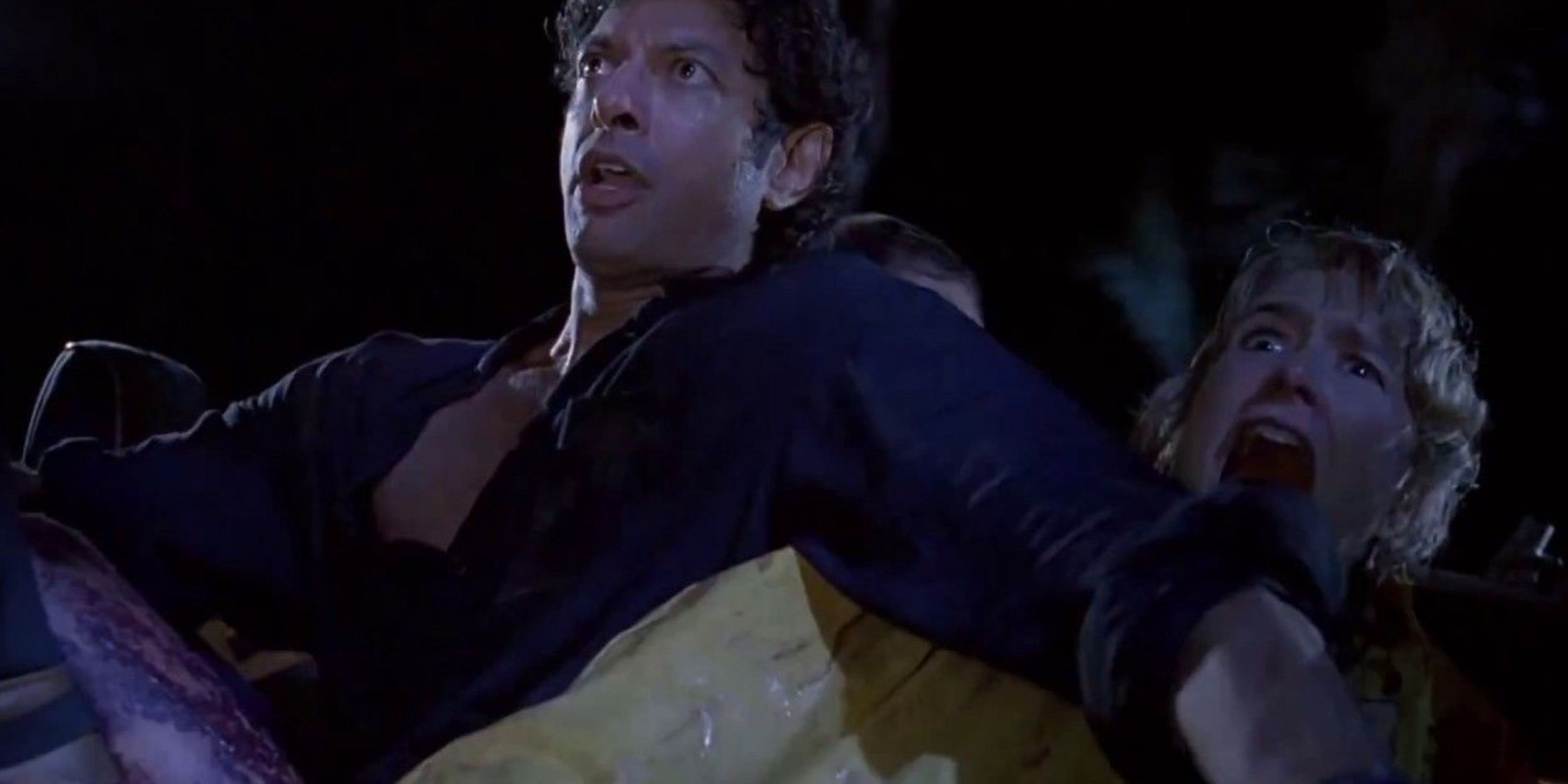 Ian Malcolm and Ellie Sattler reacting to the T.Rex in the back of the jeep in Jurassic Park