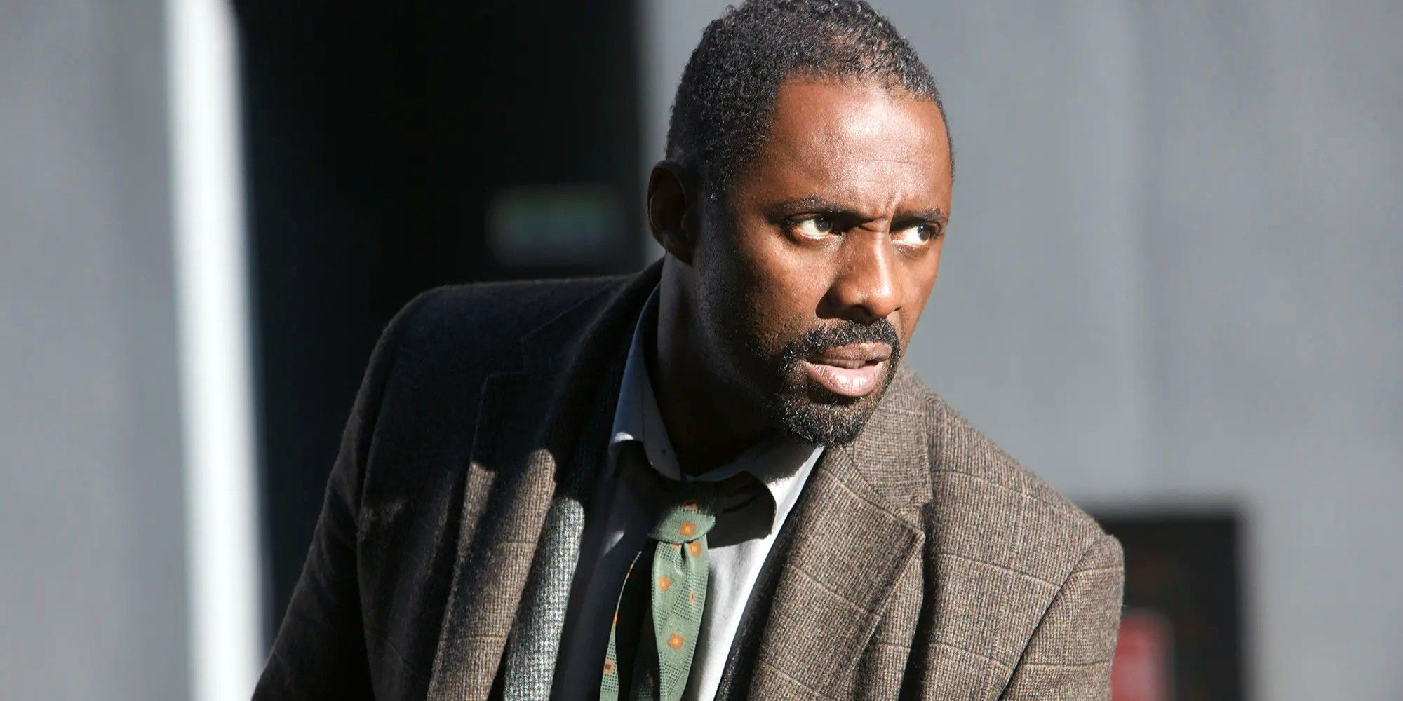 Idris Elba as Luther looking to his side concerned.