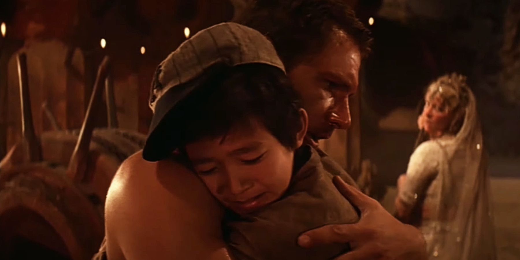  Ke Huy Quan as Short Round and Harrison Ford as Indy hug each other in Indiana Jones and the Temple of Doom