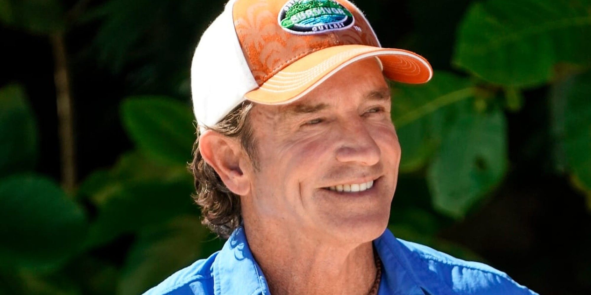 Jeff Probst on Survivor 44 smiling in orange hat with series logo
