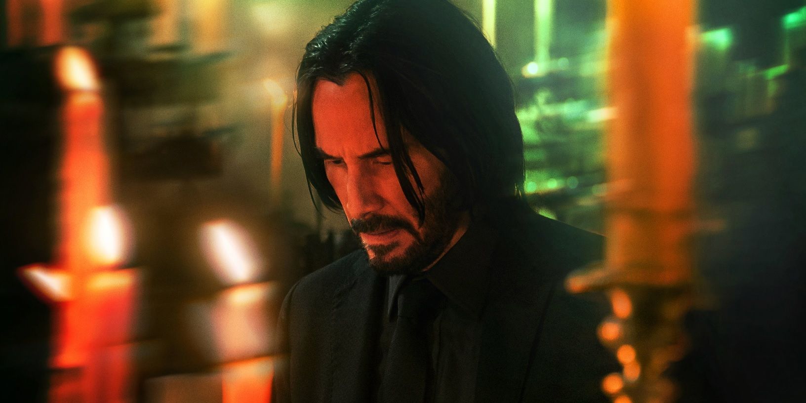 John Wick lights a candle in a church in John Wick Chapter 4