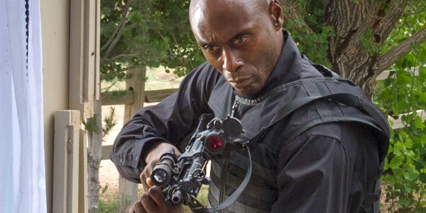 Lance Reddick as Major Carver holding a gun in The Guest