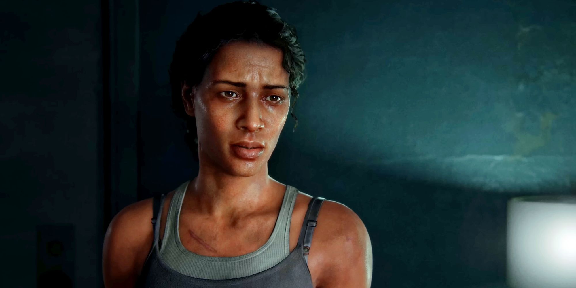 Marlene in The Last of Us Part 1, looking at Joel off screen in a dimly lit hospital room.