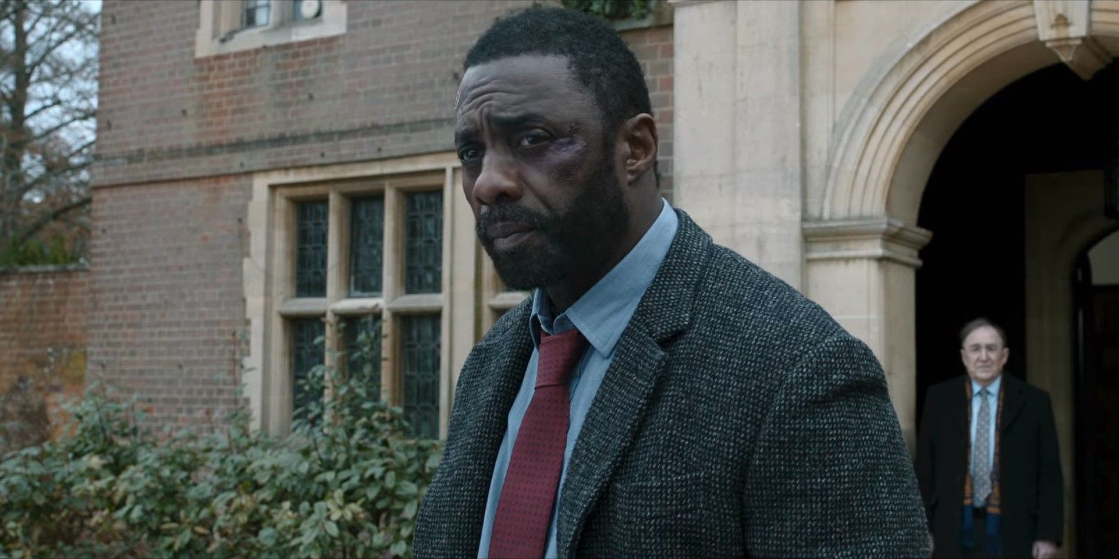 Idris Elba exits an old building in Luther