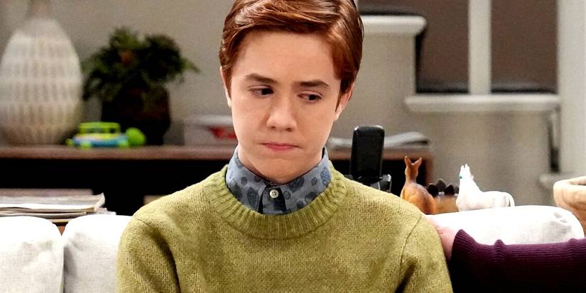 Ames McNamara's Mark sitting on a couch frowning in The Conners