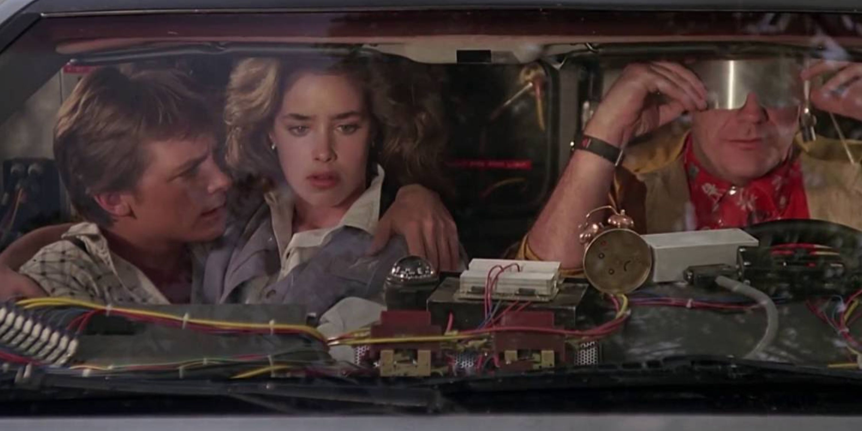 Marty, Jennifer, and Doc in the front seat of the DeLorean at the end of Back to the Future