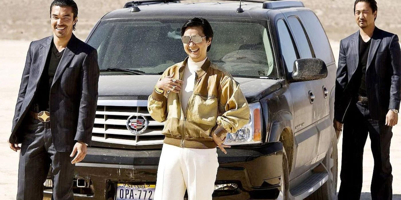 Mr Chow standing by his car with guards on The Hangover