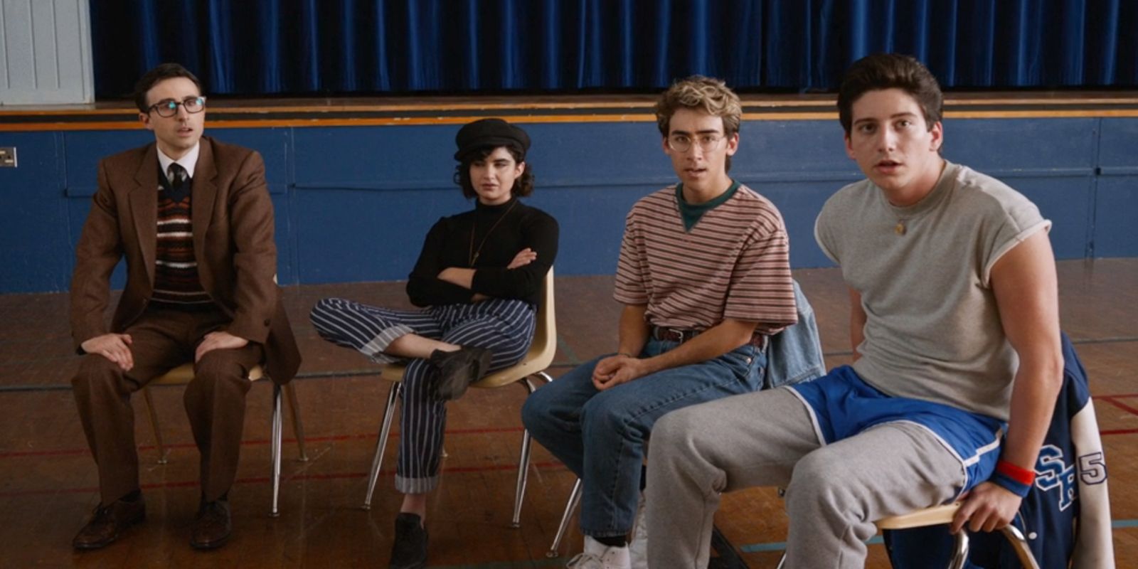 El Sr. Martin, Ronds, Charlie y Wally están sentados en un banco en el gimnasio del equipo de porristas de la escuela.