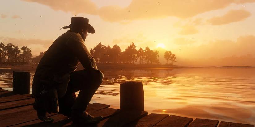 A character overlooks a lake at sunset in Red Dead Online.
