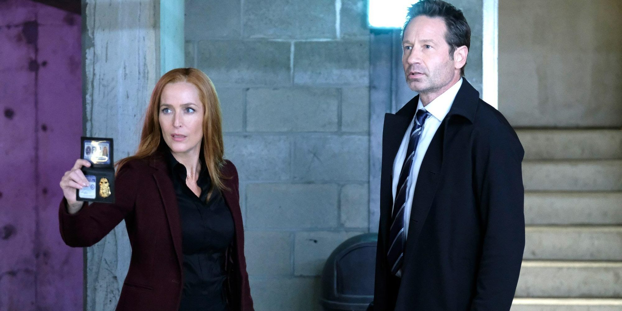 Gillian Anderson's Scully showing her badge while David Duchovny's Mulder looks in the X-Files revival
