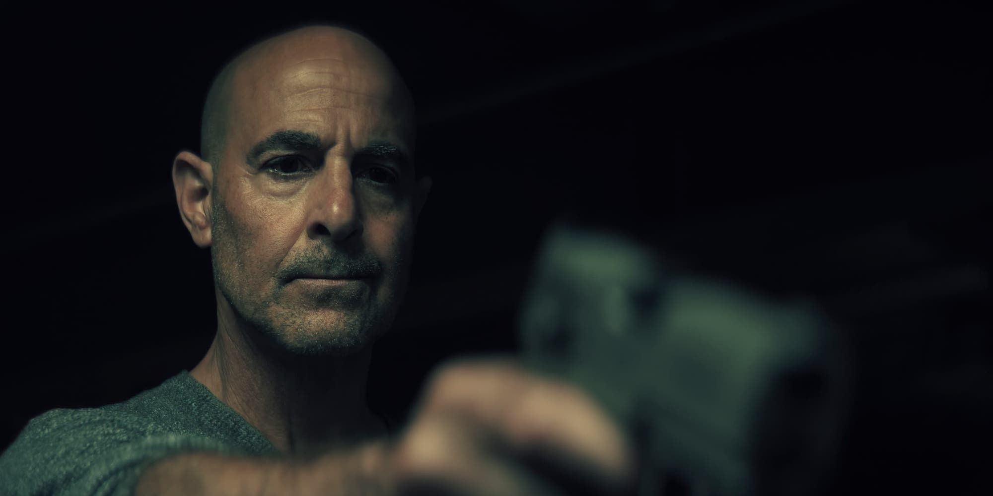 Stanley Tucci segurando uma arma na Cidadela