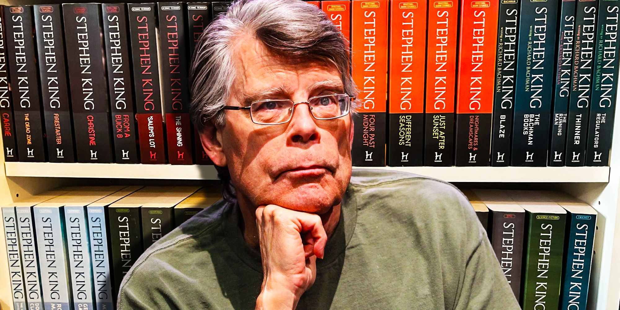 Stephen King sitting in front of his novels