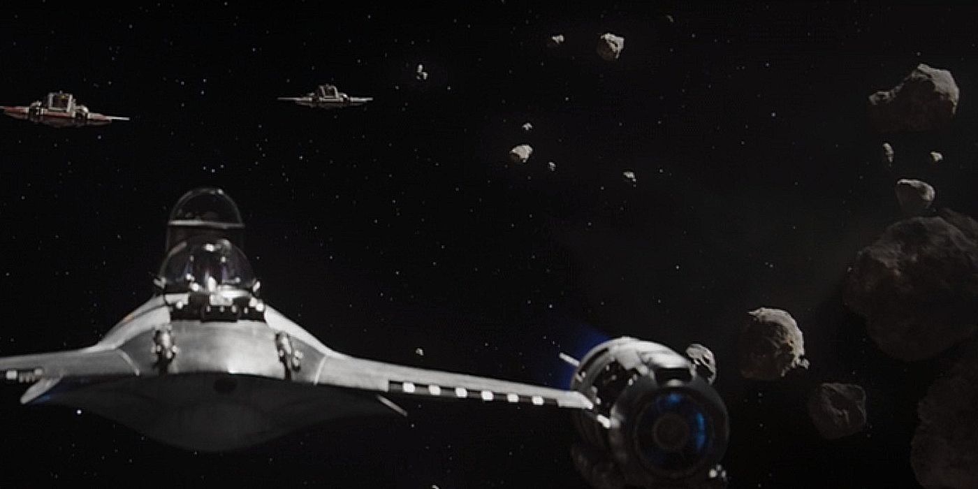 The Mandalorian in his N-1 Starfighter being chased by pirates through an asteroid field