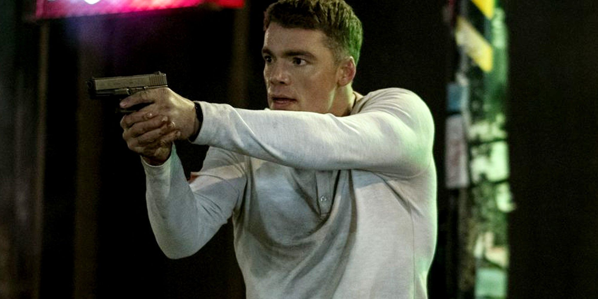 Gabriel Basso como Peter em The Night Agent segurando uma arma