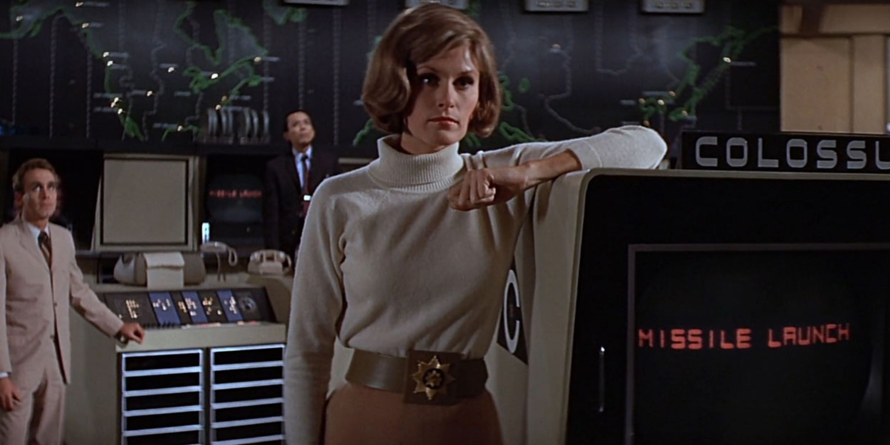 Three characters standing around computers in Colossus The Forbin Project
