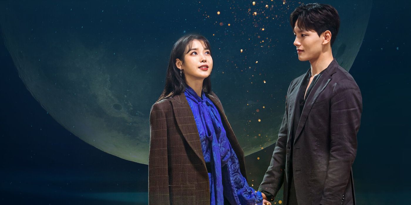 Two main cast members from Hotel Del Luna holding hands in front of a giant full moon
