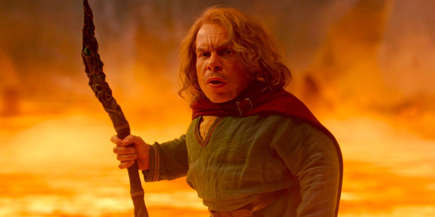 Warwick Davis as Willow, standing in front of lava.