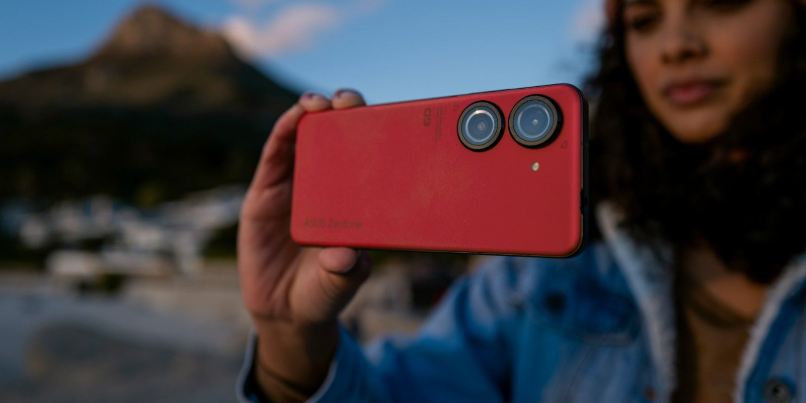Se muestra el Zenfone 9 rojo desde atrás mientras una persona toma una foto