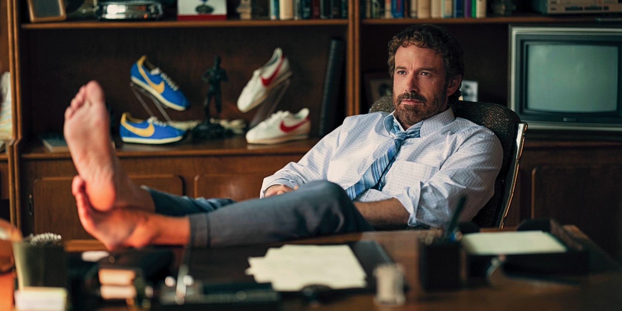 Ben Affleck as Phil Knight with his feet on his desk in Air