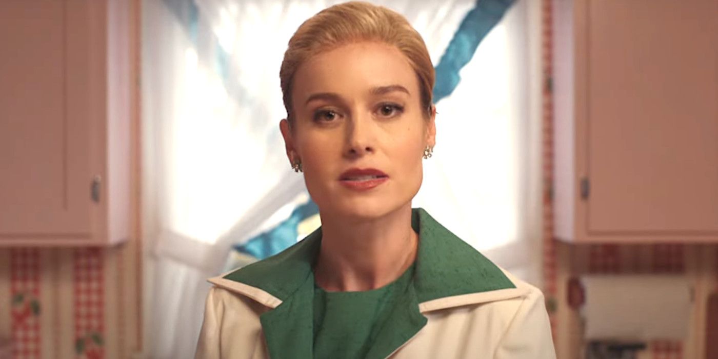 Brie Larson in Lessons in Chemistry with a severe 1950s hairstyle and period clothes, on a colorful, fake-looking old TV set, talking directly to the camera
