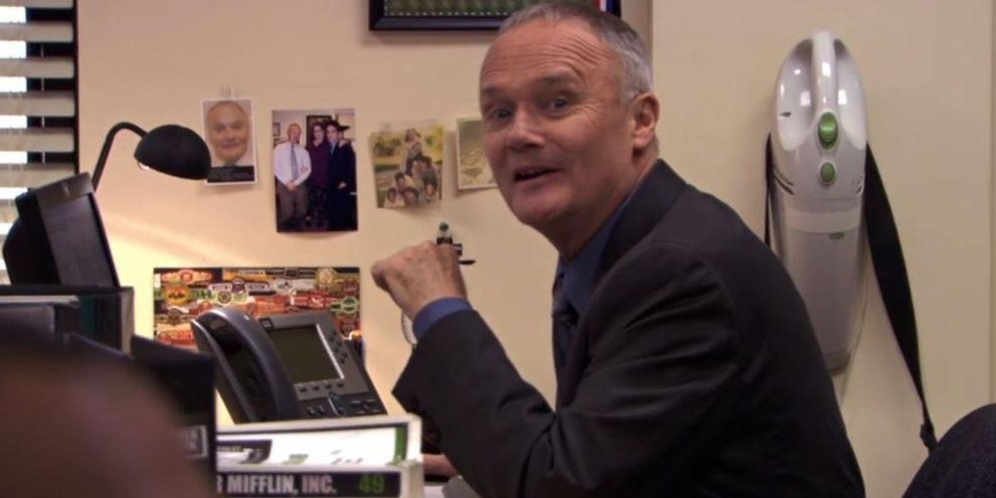 Creed sitting at his desk in The Office