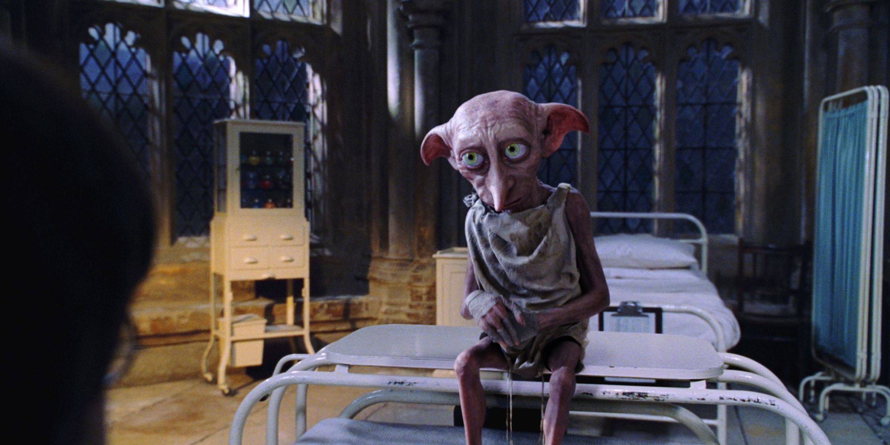 Dobby sits on the end of Harry Potter's bed in Chamber of Secrets