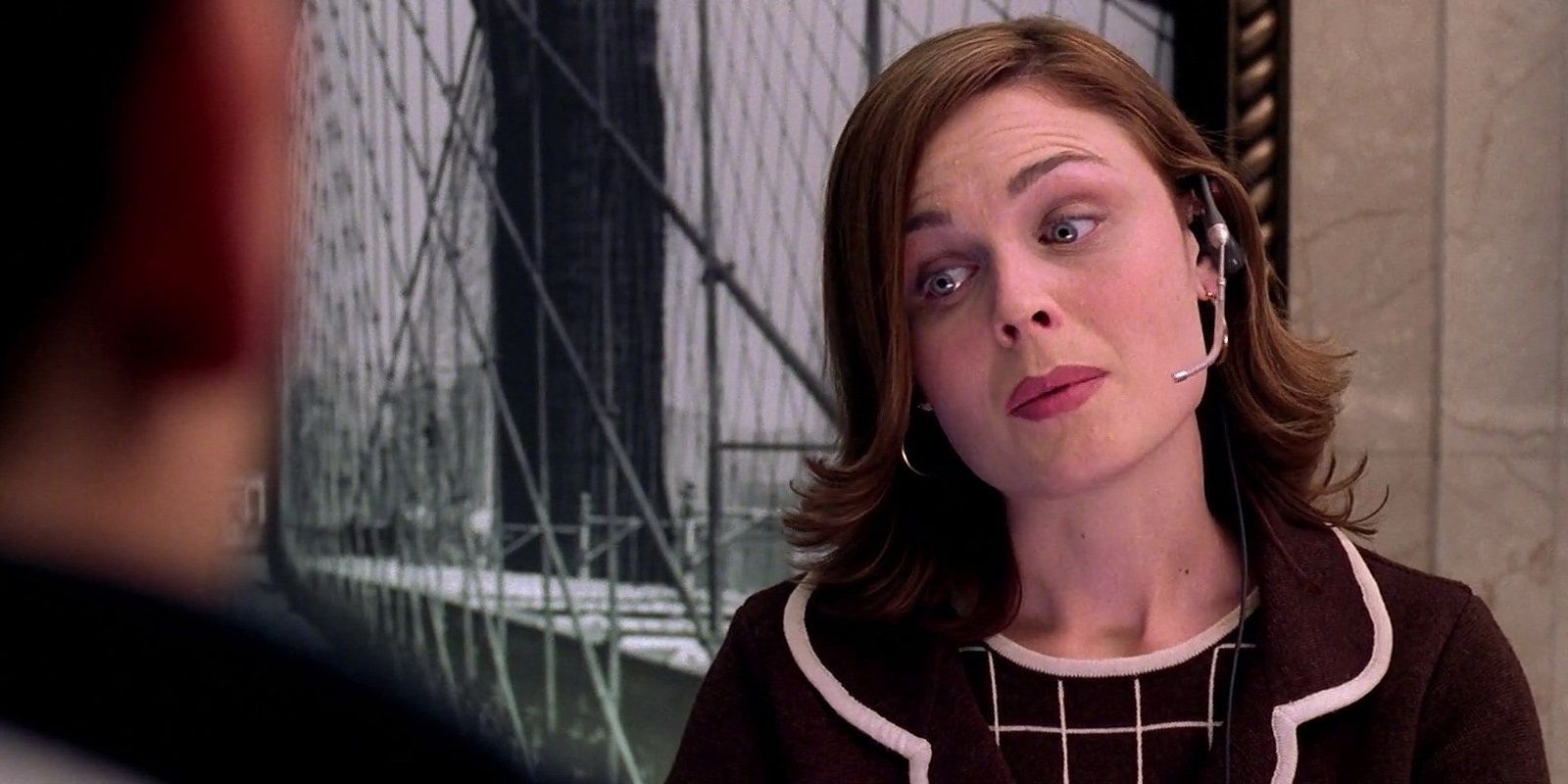 Emily Deschanel as a receptionist behind a desk in Spider-Man 2