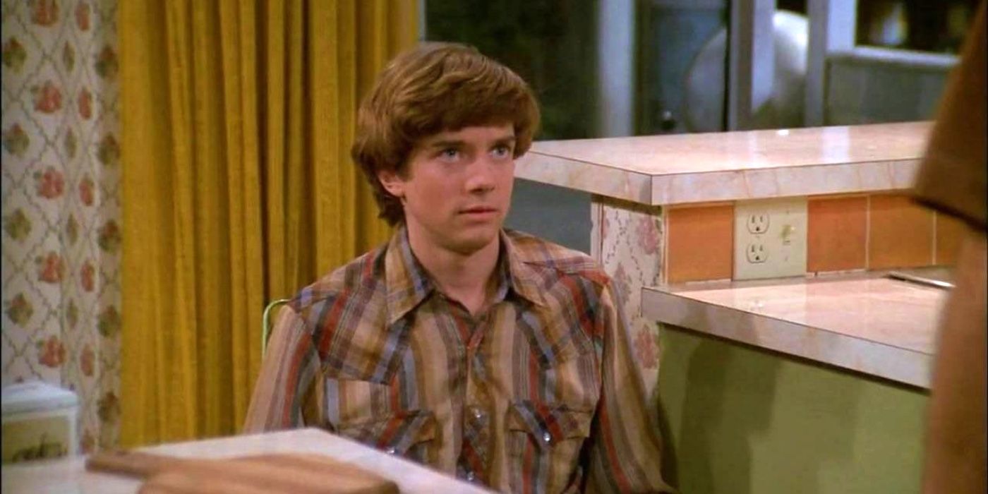 Eric sitting at the table and looking scared in That '70s Show