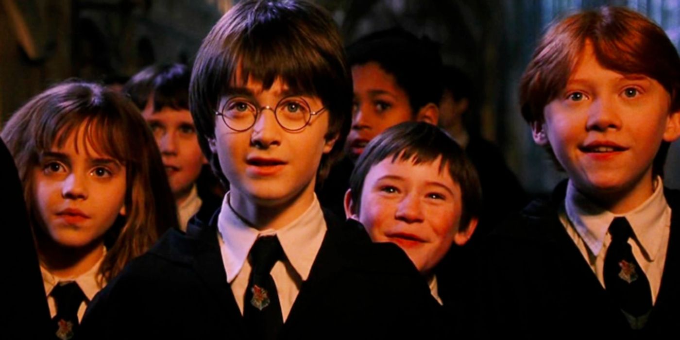 Hermione, Harry, Simas e Ron olhando para frente com espanto em Harry Potter e a Pedra Filosofal.