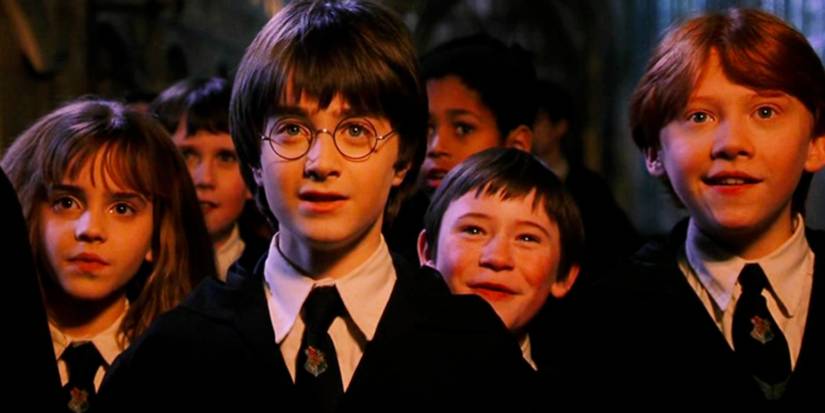 Hermione, Harry, Seamus, and Ron staring ahead in amazement in Harry Potter and the Sorcerer's Stone.