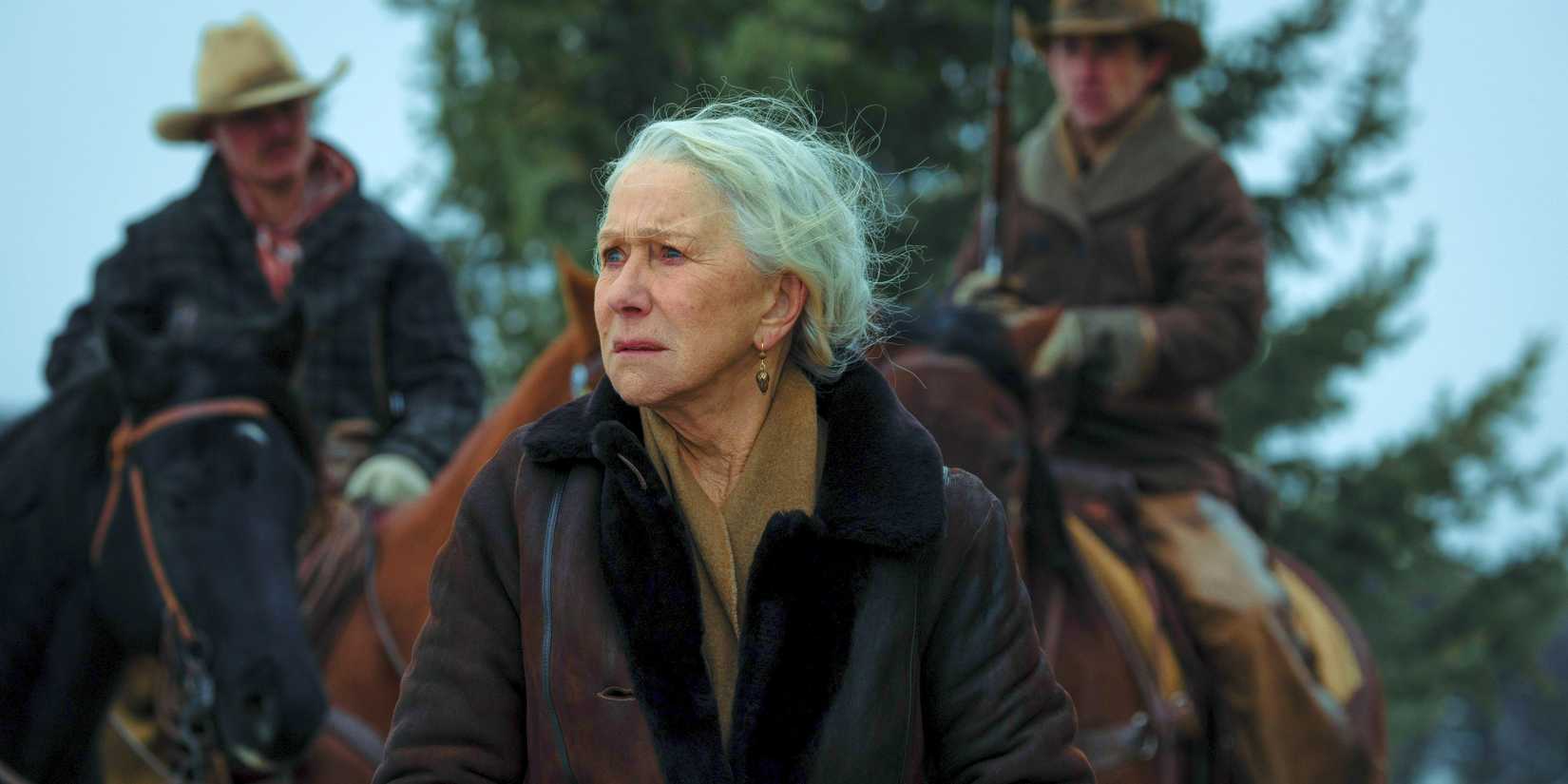 Helen Mirren as Cara Dutton in 1923 looking worried and standing in front of two men on horseback