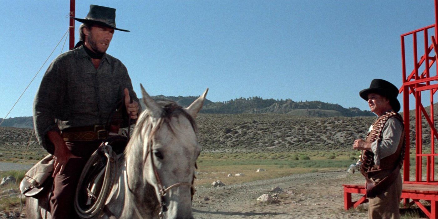 Clint Eastwood talks to another man while riding a horse in High Plains Drifter 