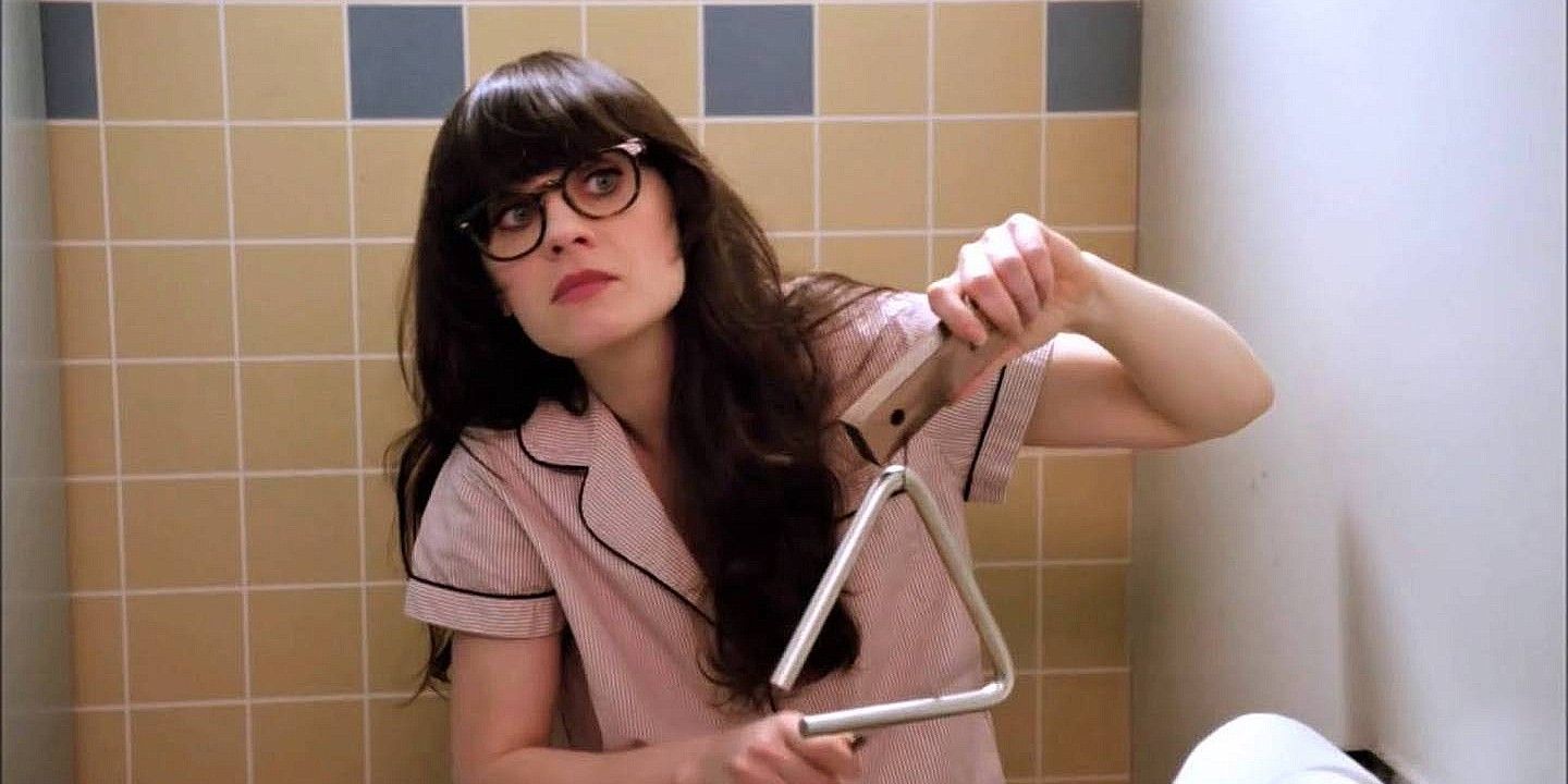 Jess with a triangle in a bathroom stall in New Girl
