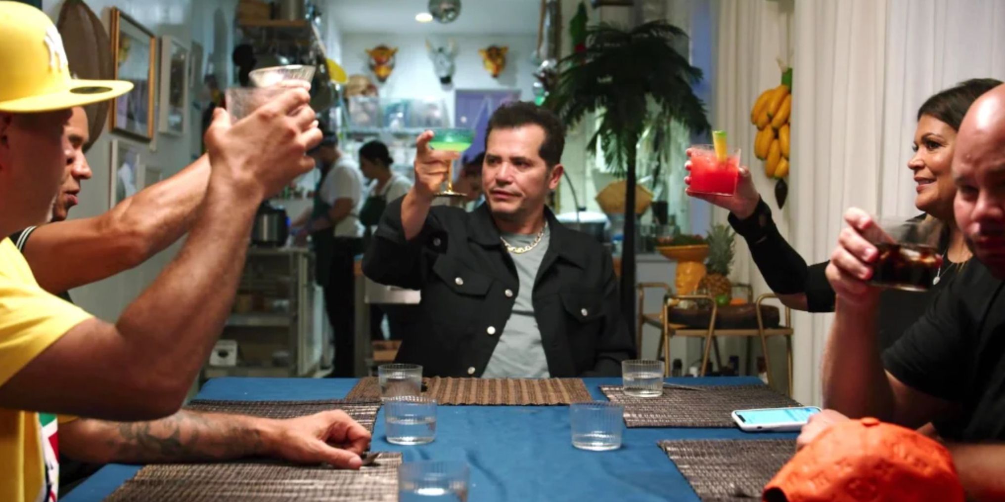 John Leguizamo brinda con un grupo de personas en una mesa en Leguizamo hace América