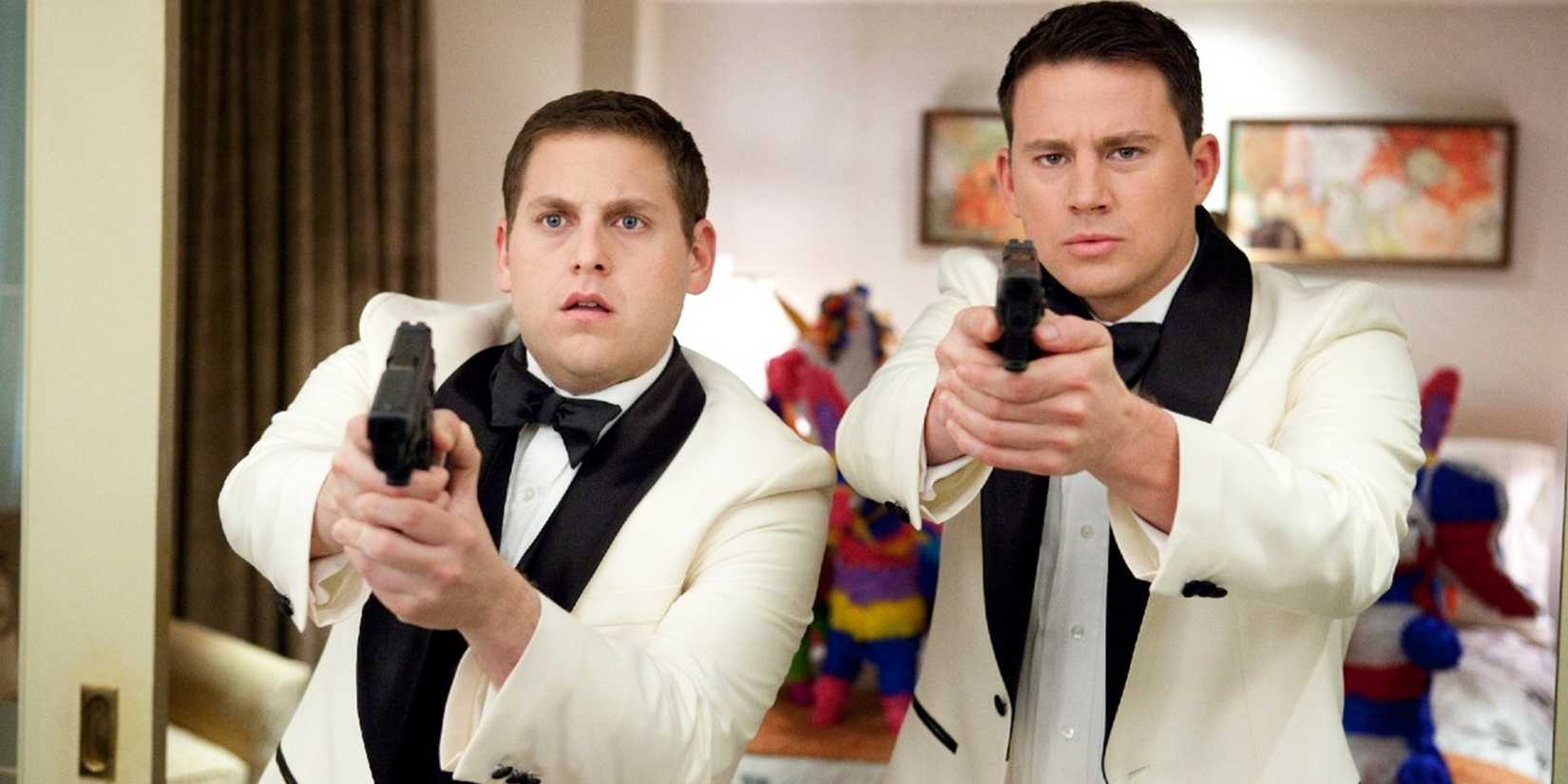 Jonah Hill and Channing Tatum with guns and wearing tuxedos in 21 Jump Street