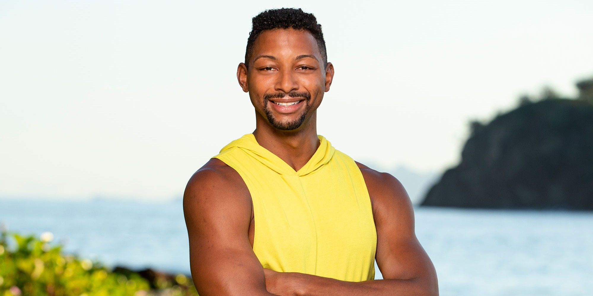 Josh Wilder from Survivor 44 yellow shirt smiling outside