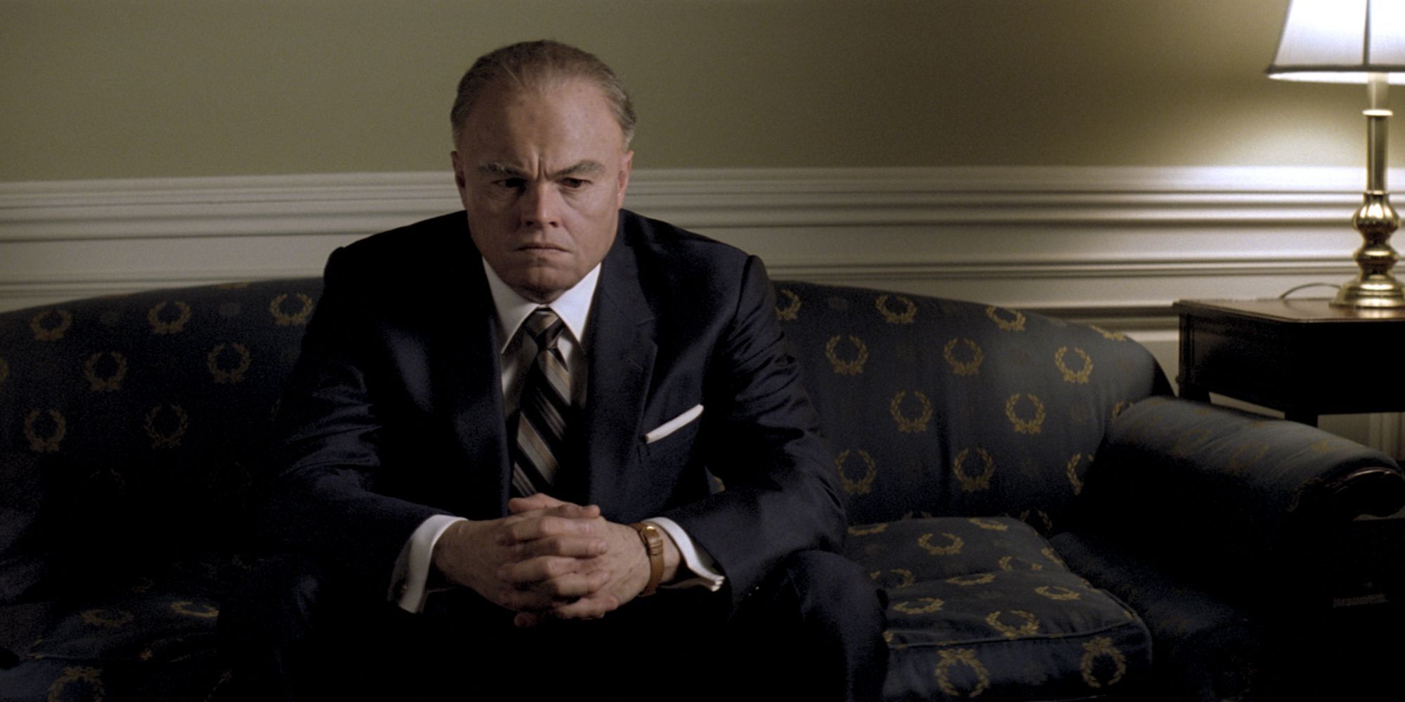 Leonardo DiCaprio as J. Edgar Hoover sitting on a couch in J. Edgar.