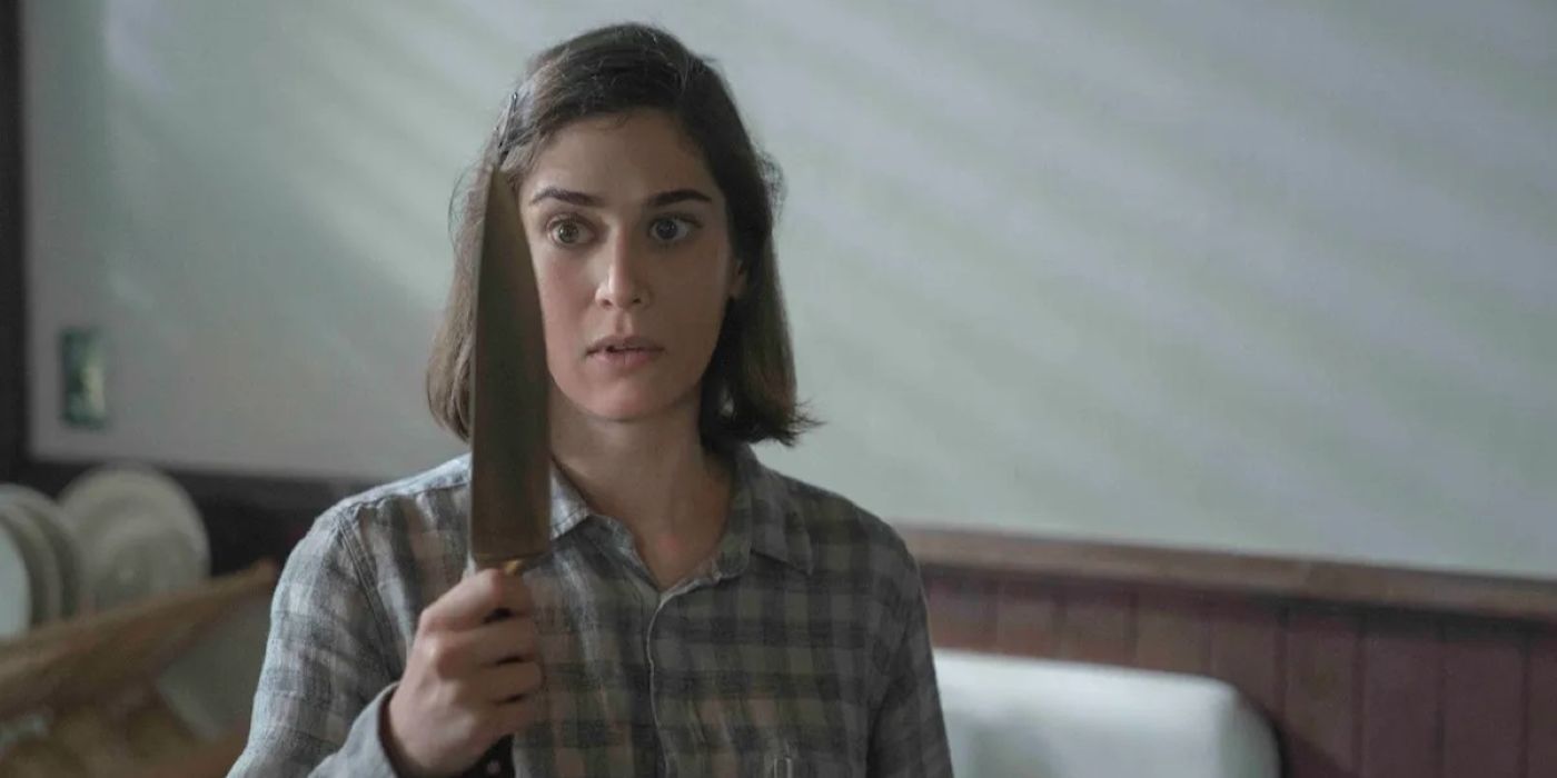 Lizzy Caplan as Alex Forrest holding a knife in Fatal Attraction. 