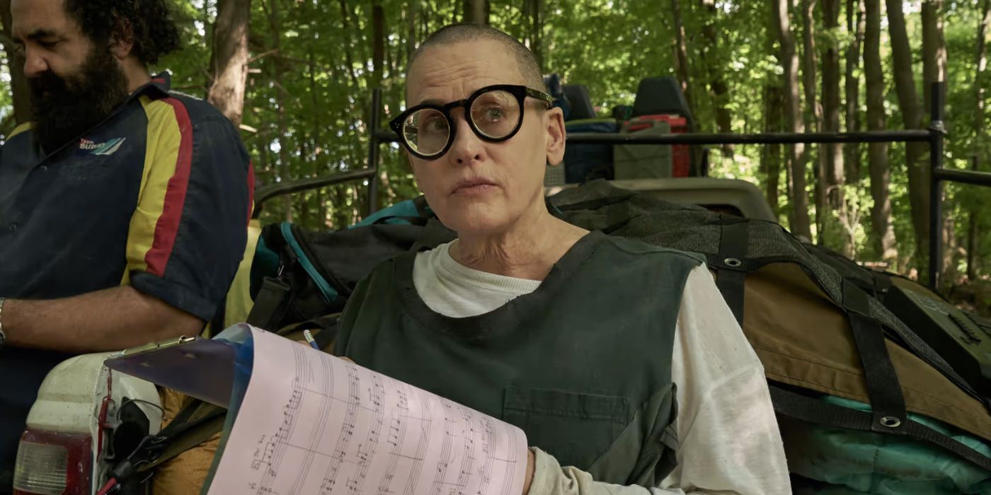 Lori Petty reading music notes and looking sideways in Station Eleven 