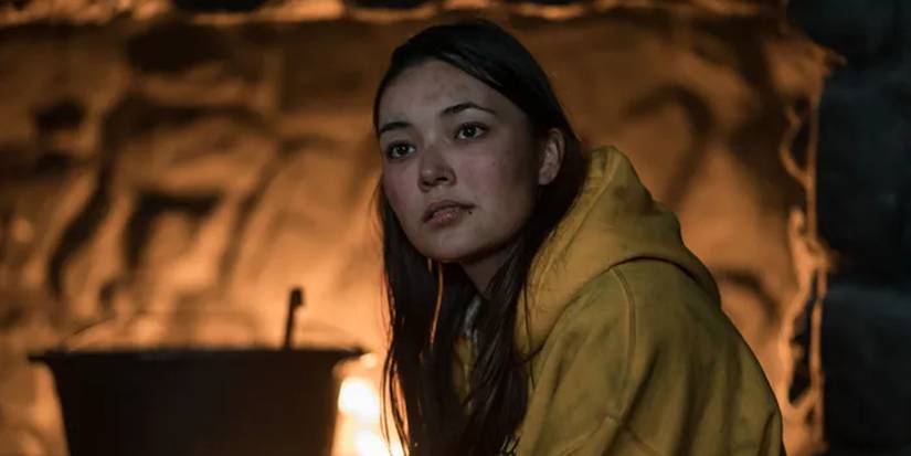 Mari sitting beside the fire in Yellowjackets