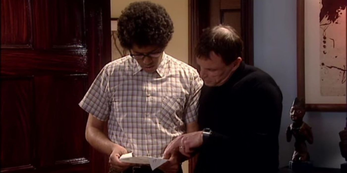 Moss and Johann looking at a paper in The IT Crowd