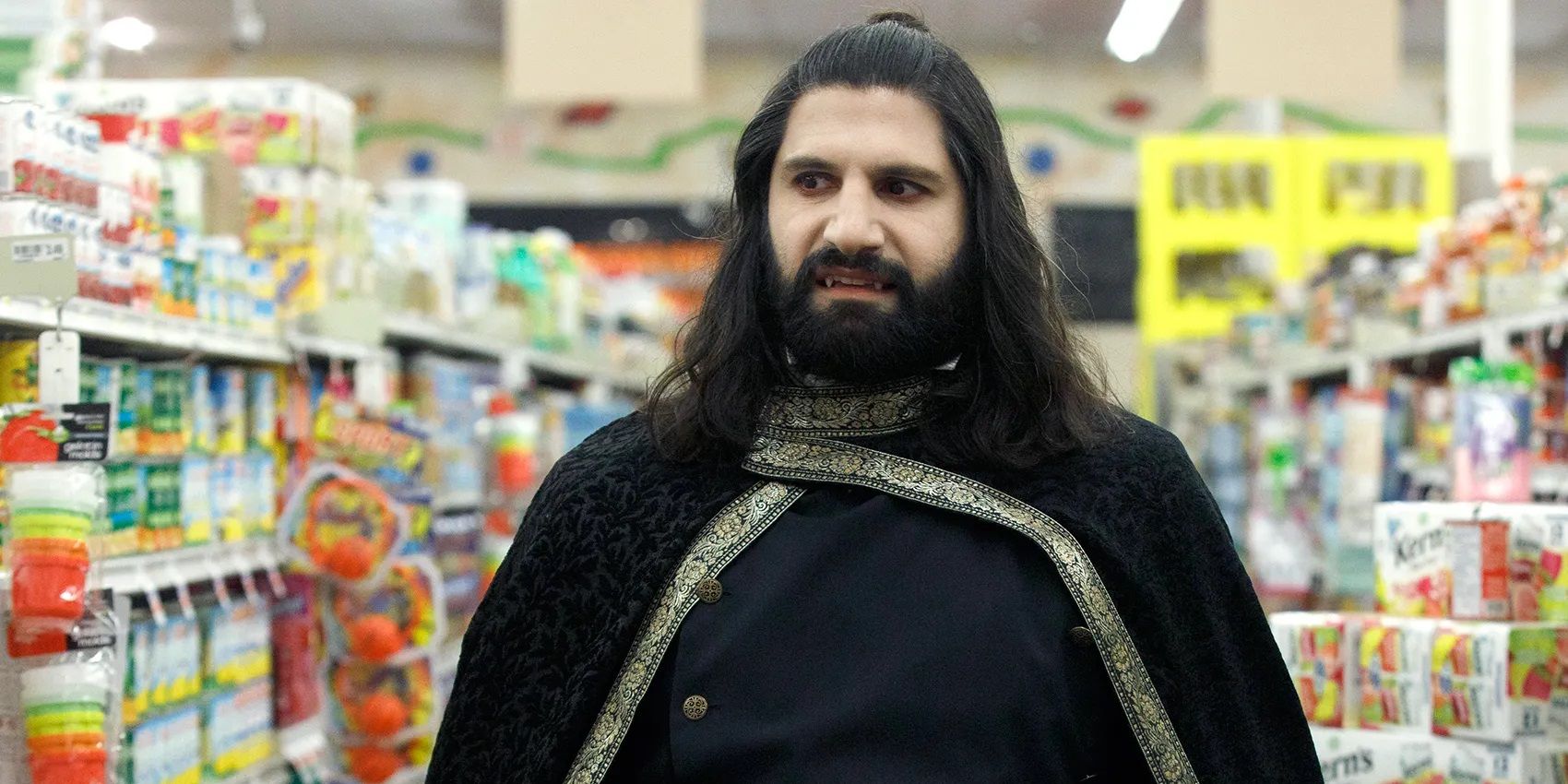 Nandor in a grocery store in What We Do in the Shadows wearing a cloak